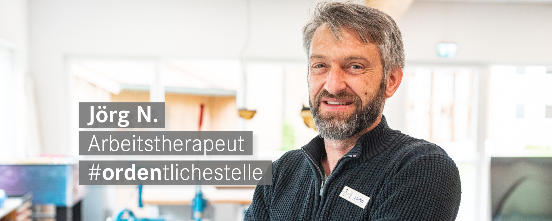 Arbeitstherapeut-mit-Vollbart-laechelt-freundlich-in-die-Kamera