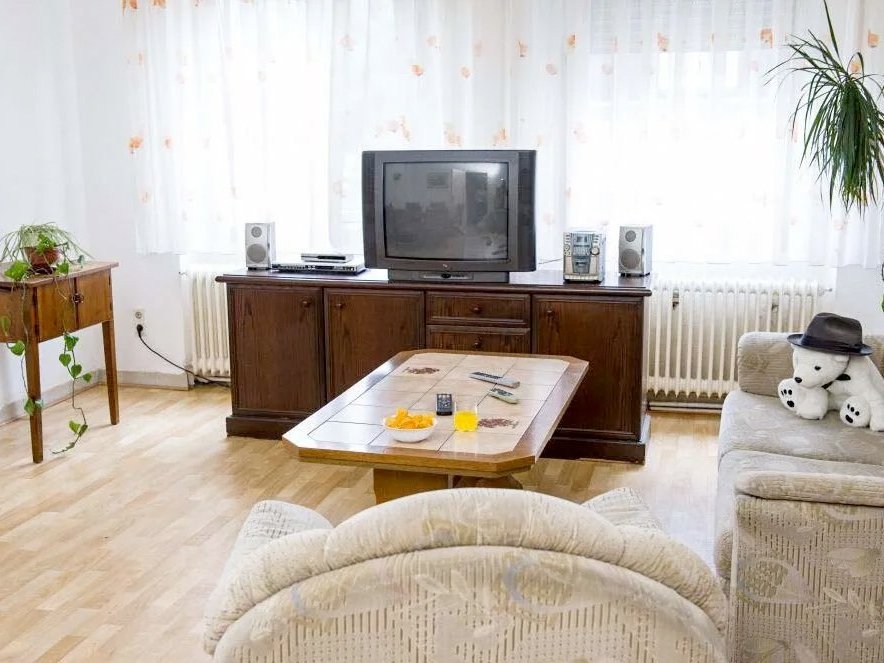 Fernsehzimmer: ein helles Sofa und ein Sessel